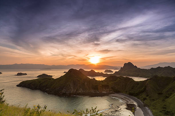From the island of Pulau Padar, on the hilltop, view of a colorful and natural sunset in the famous archipelago of Komodo in Indonesia. Komodo National Park is worldwide famous for its diving industry and is considered as one of the best location in the World.