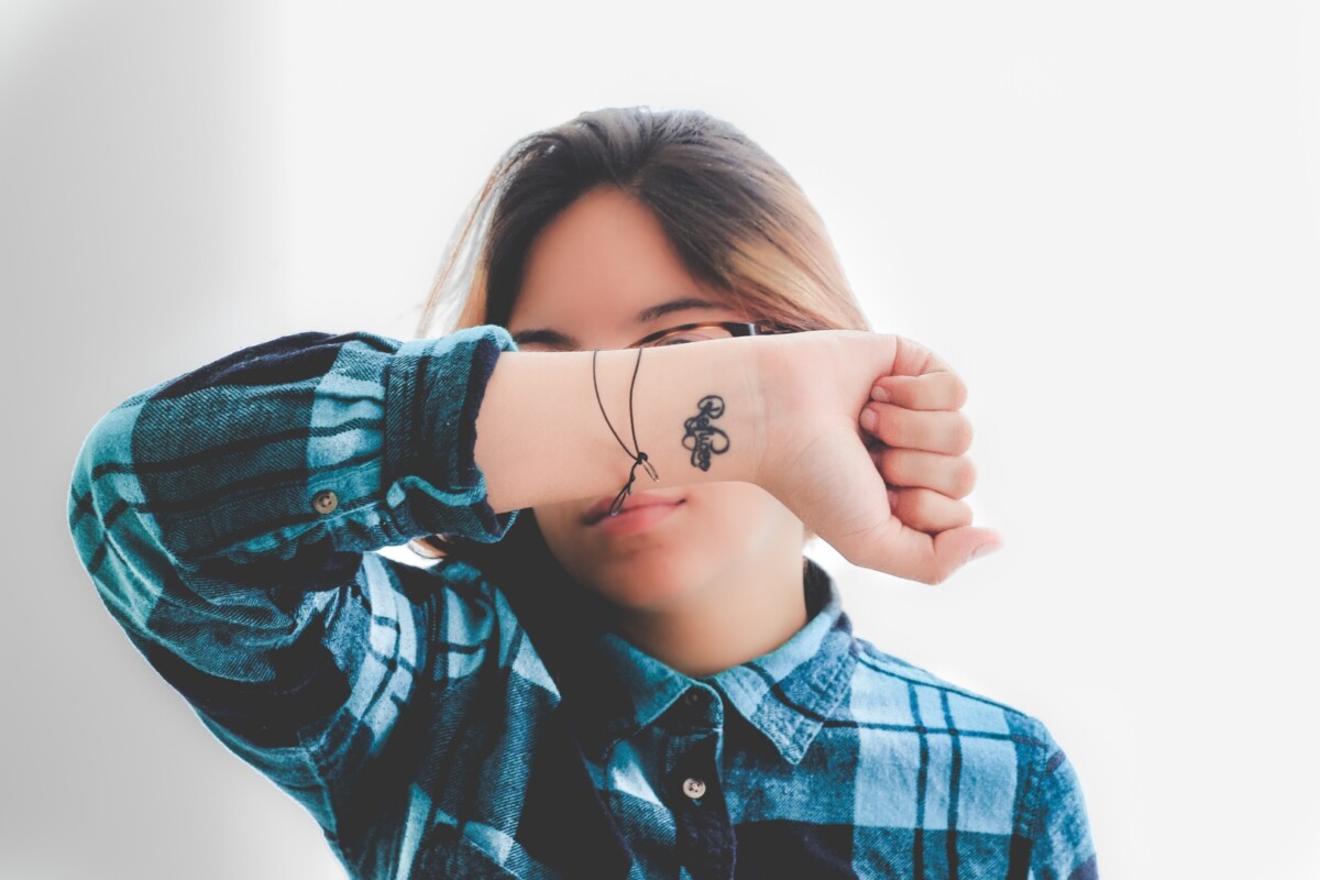 a teenager with a hand tattoo